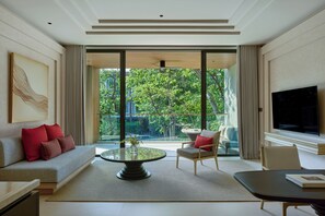 Un salon moderne avec un canapé, des fauteuils, une table basse et un téléviseur.