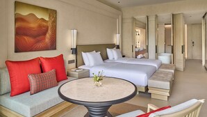 Ein Hotelzimmer mit einem Bett, einem Sofa, einem runden Tisch und einem Bild an der Wand.