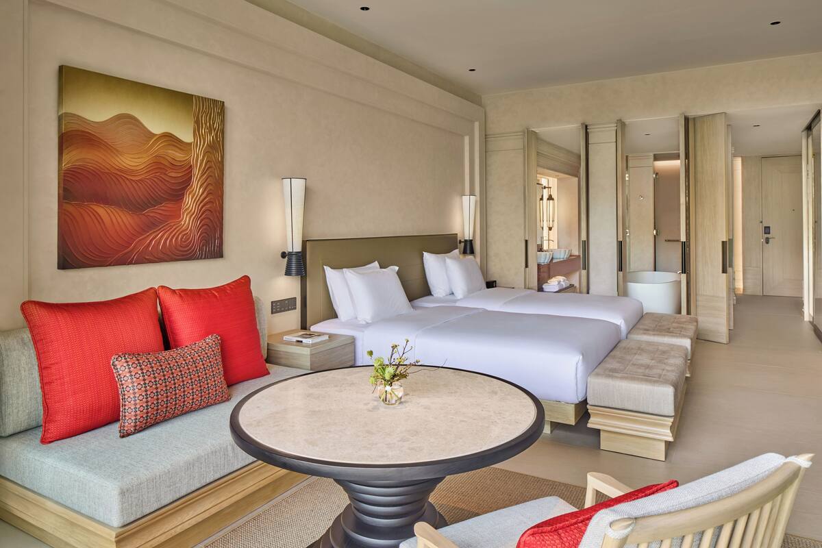 Ein Hotelzimmer mit einem Bett, einem Sofa, einem runden Tisch und einem Bild an der Wand.