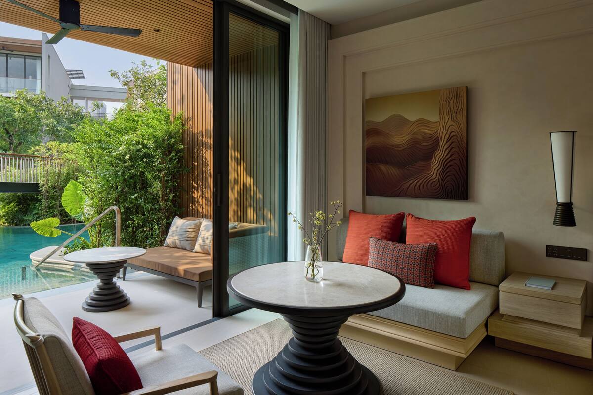 Ein modernes Zimmer mit Pool, einem runden Tisch, einer Couch und einem Gemälde an der Wand.