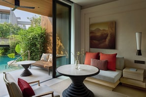 Una habitación moderna con piscina, una mesa redonda, un sofá y un cuadro en la pared.