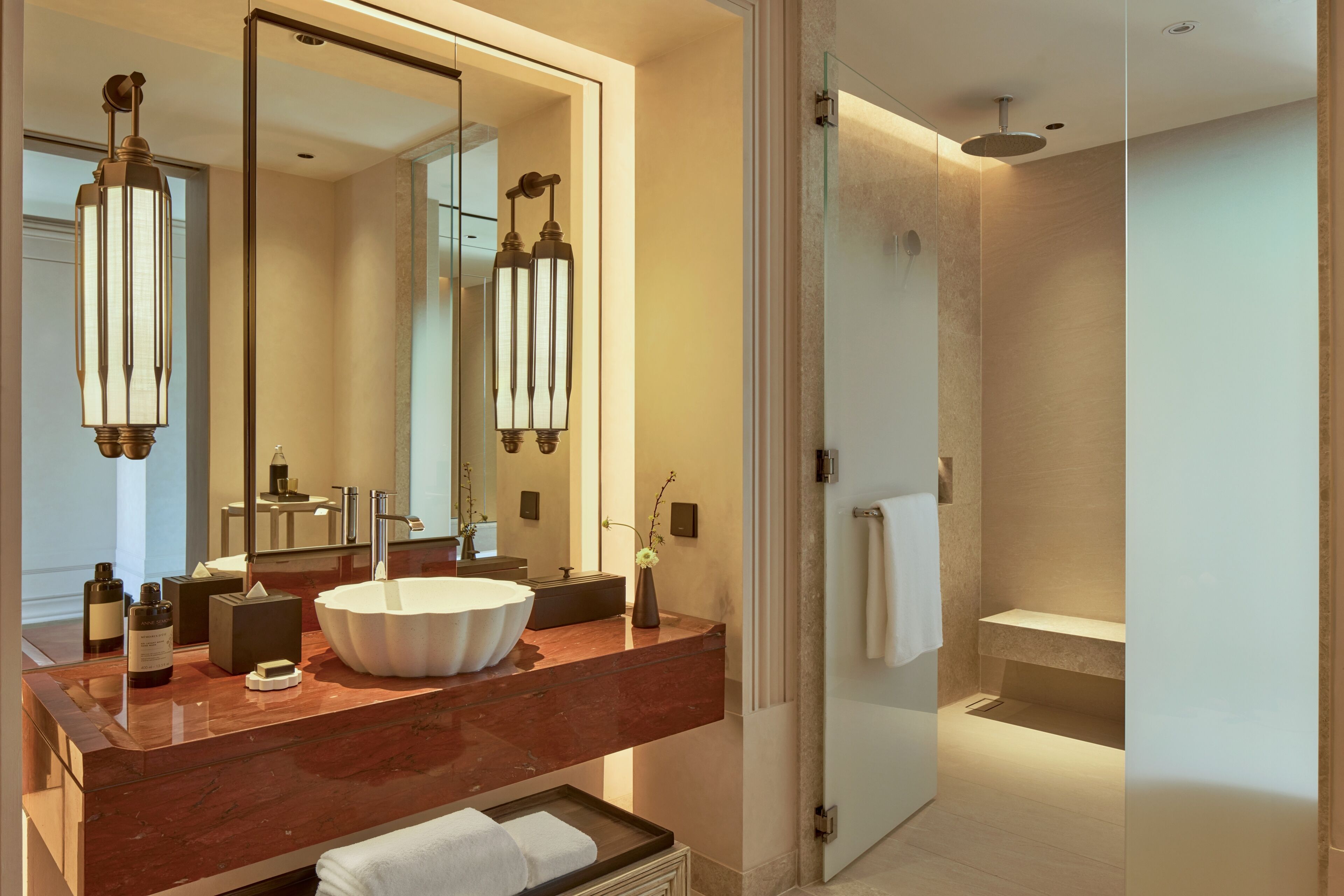 Un baño moderno con un espejo grande, un lavabo sobre encimera y una zona de ducha.