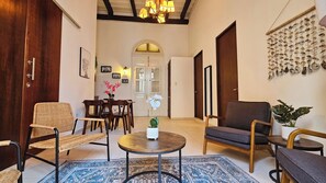A spacious living area with a dining table, chairs, a round coffee table, and a blue patterned rug. - Spanish Colonial Retreat in Old San Juan (San Juan)