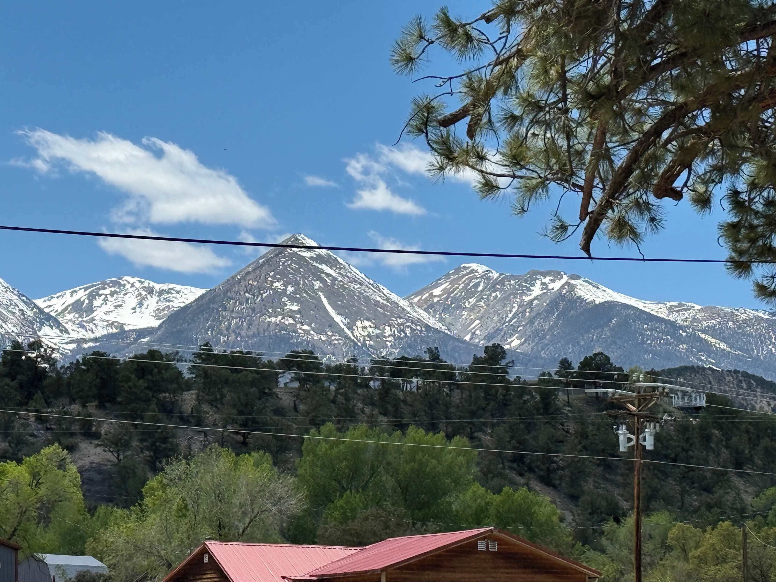 Une chaîne de montagnes aux sommets enneigés, sous un ciel dégagé.