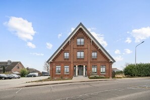 A red brick building with a gabled roof, a central entrance, and multiple windows. - Arrive & feel good in the Altes Land (Mittelnkirchen)