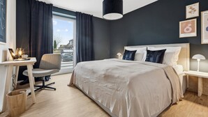 Et moderne hotelværelse med en stor seng, et skrivebord og en stol.