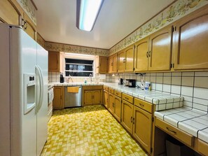 A kitchen with a refrigerator, sink, and tiled floor. - Spacious 6-bedroom house in delightful San Jose with AC (San Jose)