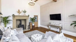A living room with a fireplace, a sofa set, a television, and a wooden ceiling. - Farm House - Sleeps 16 - Hot Tub - Pet Friendly (Skipton)