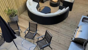 A circular outdoor seating area with a fire pit, surrounded by metal tables and chairs. - Farm House - Sleeps 16 - Hot Tub - Pet Friendly (Skipton)