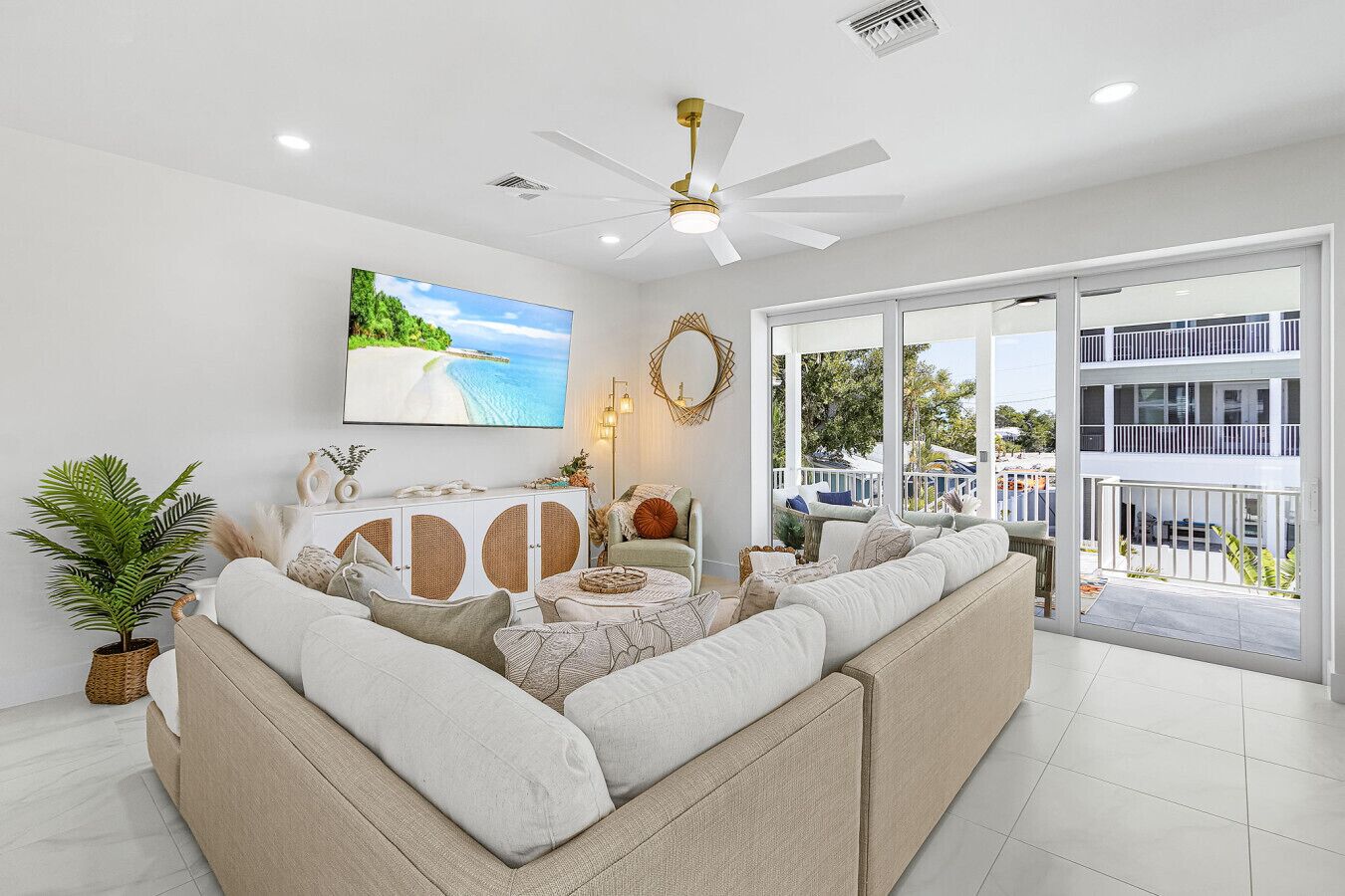 A living room with a sofa, a coffee table, a TV, and a balcony with a view.