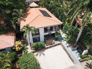 A two-story building with a tiled roof, a balcony, and a solar panel. - King Suite I Ensuite I Kitchenette | Pool, Spa & Patio I Near Beach I Suite One (Del Coco Beach)