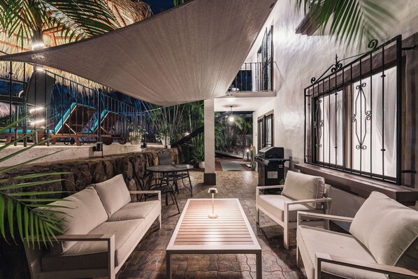 Une terrasse extérieure avec des sièges, un barbecue et une vue sur une aire de jeux avec un toboggan.
