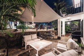An outdoor patio area with seating, a bar, and a pool. - Queen Suite + Single Bed I Full Kitchen I Pool, Spa & Patio I Suite Three (Del Coco Beach)