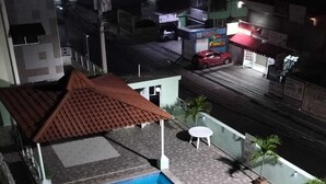 Ein Dachpool mit gefliestem Deck, einer kleinen Laube und einer Straßenansicht im Hintergrund.