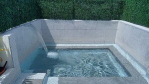Ein Whirlpool mit gefliestem Innenraum und einer Springbrunnenattrappe.
