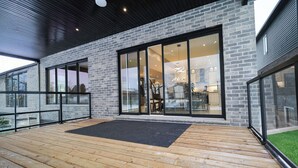 Ein modernes Gebäude mit großen Glasfenstern und einer Holzterrasse.