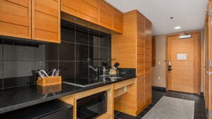 Une cuisine moderne avec des meubles en bois, un plan de travail noir et un évier.