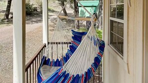 A porch with a hammock and a window.
