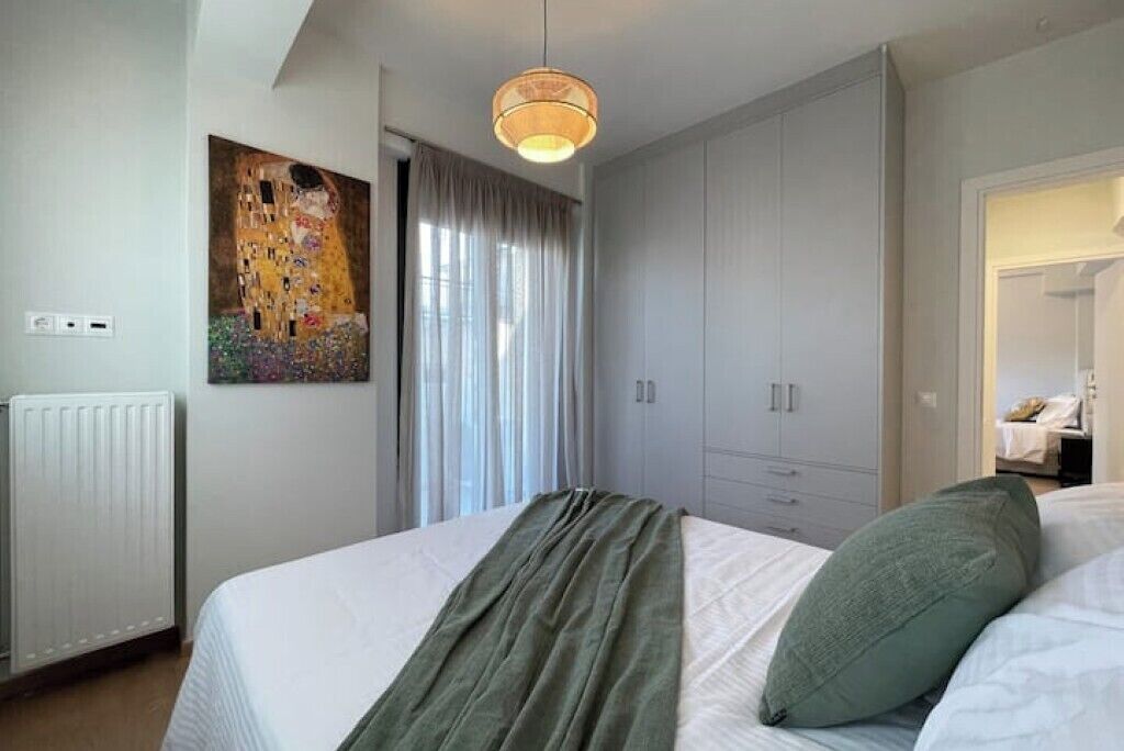 Quarto com cama, pintura, radiador e guarda-roupa.
