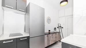 Een moderne keuken met een koelkast, kastjes en een aanrecht.