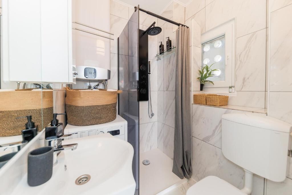 A modern bathroom with a shower, toilet, and sink.