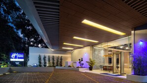 Ein moderner Hotel Eingangsbereich mit einer Rezeption, Zimmerpflanzen und einem Schild für Holiday Inn Express.