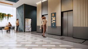 Eine moderne Lobby mit einem Getränkeautomaten, einer Sitzecke und einer großen Karte an der Wand.