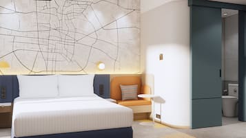 A modern hotel room with a large bed, a map wall, a small seating area, and a separate bathroom.