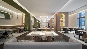 A modern restaurant with a central dining area, booths, and a bar area. - Holiday Inn Quanzhou Jinjiang Airport by IHG (Quanzhou)