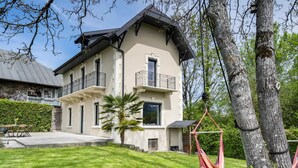 A two-story house with a balcony, a lawn, and a hammock. - Villa Côte des Vignes x Annecy 15’ (Charvonnex)