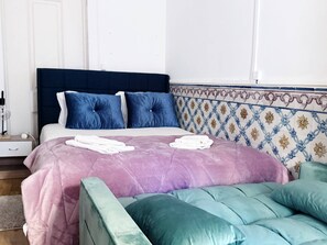 Ein Schlafzimmer mit einem Bett, Kissen, einem Nachttisch und einer Wand mit dekorativem Muster.