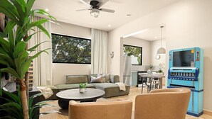En moderne stue med sofa, sofabord og stole, et køkkenområde og en blå automatrejse.