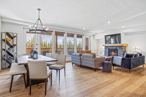 A spacious living area with a fireplace, a dining table with chairs, and a sofa set. - Beautiful 3BR |Mountain View| Sleeps 12 | Downtown (Canmore)