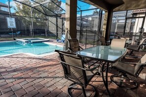 Un espacio al aire libre cubierto con piscina, mobiliario de patio y un cartel que indica que no se permite bañarse.