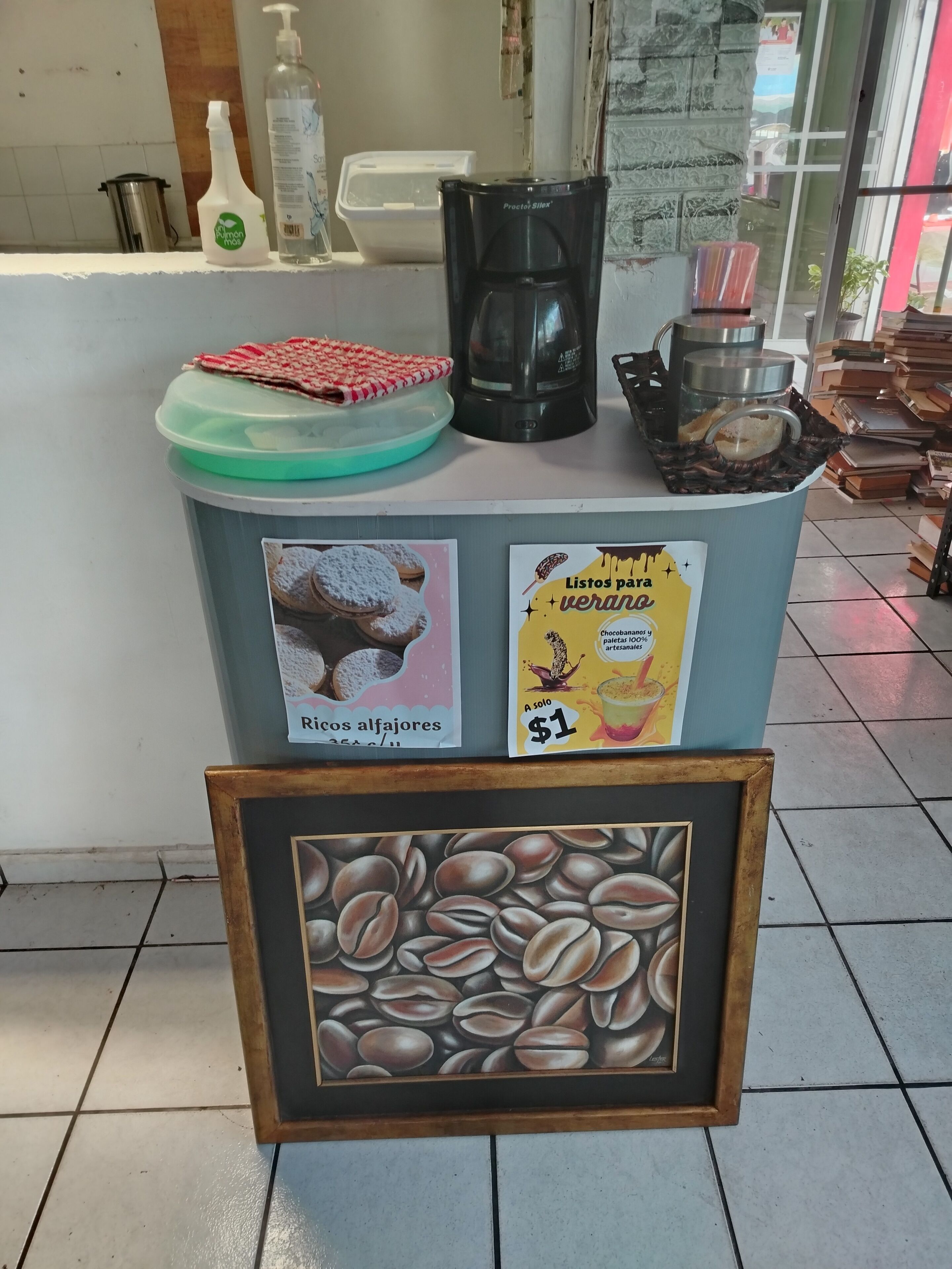 A coffee station with a coffee maker, a bottle of milk, and a sign advertising coffee beans.