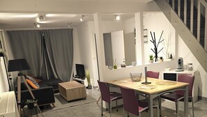 Un salon moderne comprenant un coin repas, un escalier et une cuisine.