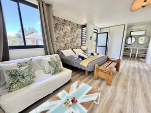 Un dormitorio moderno con cama, sofá y una mesa de centro de madera.