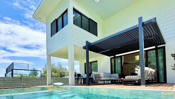 A modern two-story house with a swimming pool, outdoor seating, and a covered patio area. - Villa Vaimoeani + bungalow  - pool - serenity in Moorea, Haapiti - 8 pers (Haapiti)