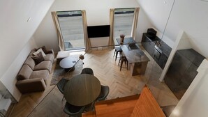 A loft-style apartment with a dining area, kitchen, and seating space.