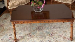 A room with two upholstered chairs, a dark wooden coffee table, a small black side table with a potted plant, and a framed painting on the wall. - Entire Peaceful 3BR Guest Suite Upper Level West Vancouver: WiFi & Parking (West Vancouver)