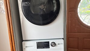 A stacked washer and dryer unit with control panels and a door with a window. - Entire Peaceful 3BR Guest Suite Upper Level West Vancouver: WiFi & Parking (West Vancouver)