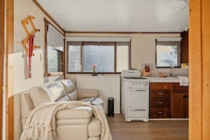 A compact living space with a sofa, a kitchenette, and a window. - Treetop Annex, Near Village w/ Forest Views (Big Bear Lake)