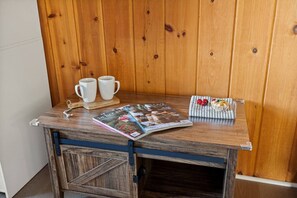 Ein Holztisch mit einer Zeitschrift, zwei weißen Tassen und einem Teller mit Essen.