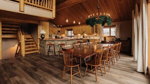 A spacious kitchen with a central island, wooden dining table, and chairs. - Cliffhanger Cabin, Near Snow Summit w/ Hot Tub (Big Bear Lake)