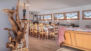 Una cucina moderna con mobili in legno, un'area pranzo con sedie e tavolo, e un letto con coperta rosa.