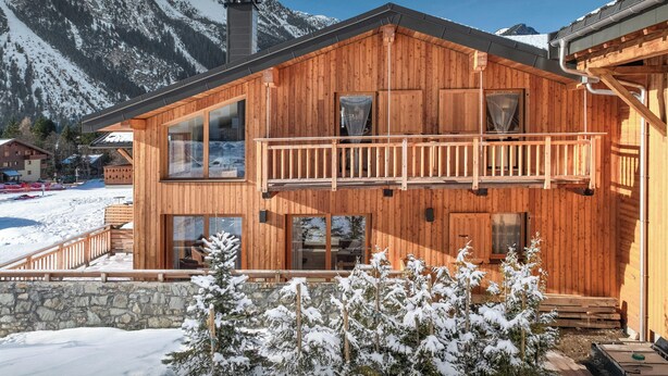 A wooden chalet with a balcony, large windows, and a stone wall foundation. - Chalet Arpitan Orizon - Chalet in the Vanoise National Park - OVO Network (Pralognan-la-Vanoise)