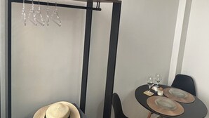 Ein kleines Zimmer mit einem Bett, einem kleinen Tisch mit zwei Stühlen und einer Pendelleuchte.