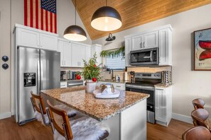 A modern kitchen with stainless steel appliances, a granite countertop, and a wooden ceiling. - BIG Lake View, Private Hot Tub on deck w/Tv & Firepit; High End Design & Comfort (Branson)
