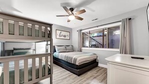 A bedroom with a bunk bed, a bed, a desk, a ceiling fan, a window with curtains, and a staircase visible through the window. - Indoor Pool, Hot Tub, PT Royale, Bunk Room, LAKE! (Branson)