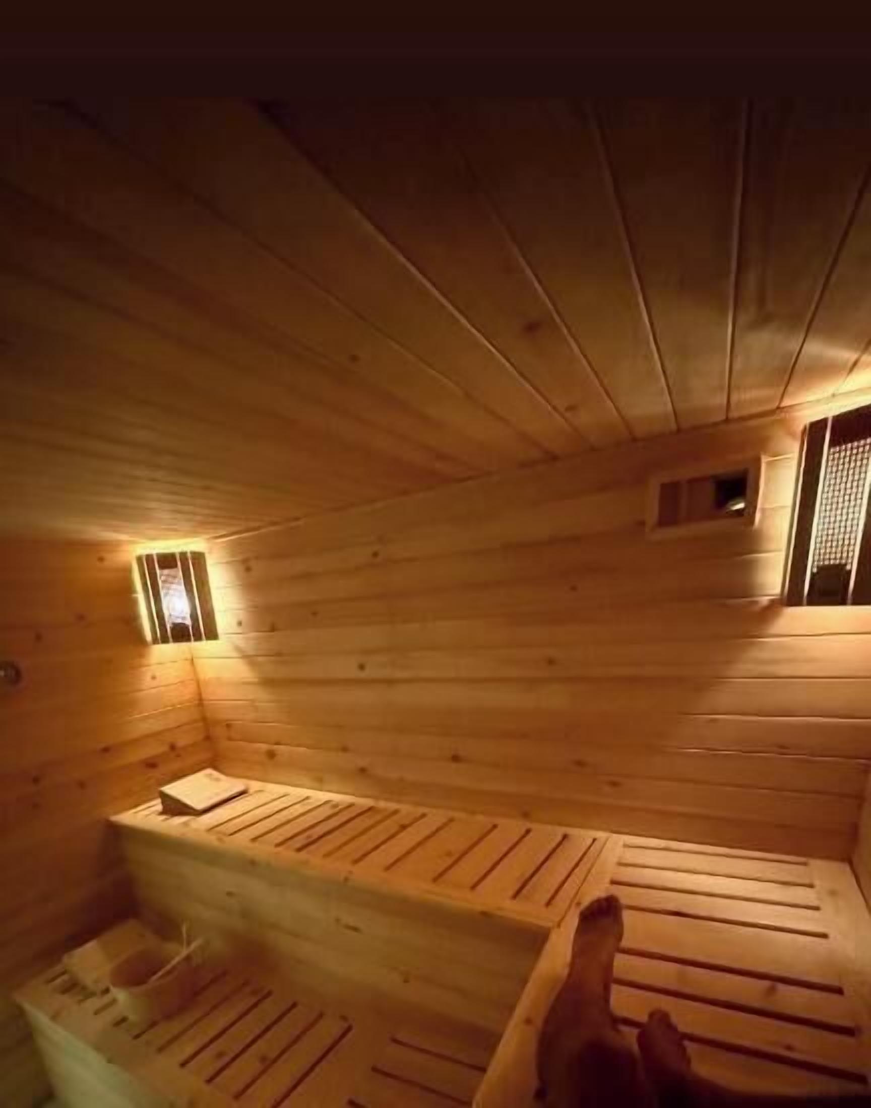 Un sauna con bancos de madera y una ventana pequeña.